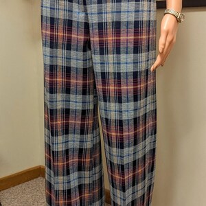 Op de afbeelding: Brede, geruite broek met een blauw, oranje en rood geruit patroon. De broek heeft een omslagzoom en een rits.