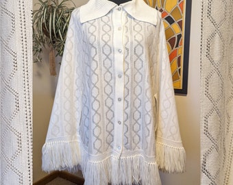 Poncho cape vintage des années 1960 en tricot blanc à grand col et boutonné sur le devant avec franges