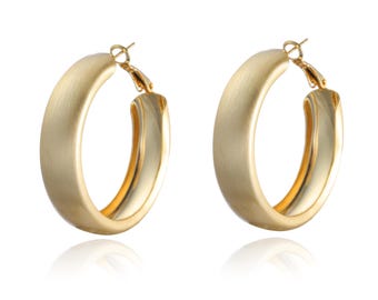 May include: A pair of gold hoop earrings with a brushed finish. The earrings are thick and have a rounded shape.