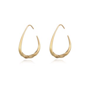 May include: A pair of matte gold hoop earrings featuring an open, teardrop-shaped design with a subtle twist at the base. The earrings have a smooth, curved silhouette that tapers toward the top, creating a continuous, fluid form in a warm metallic tone.