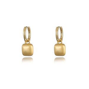 May include: A pair of gold hoop earrings with a square-shaped pendant hanging from each hoop.