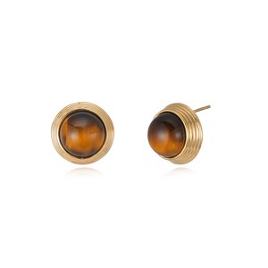 May include: A pair of stud earrings with a round, polished, brown gemstone set in a gold-coloured, ridged bezel. The earrings have a post backing. The gemstones have a warm, amber colour.