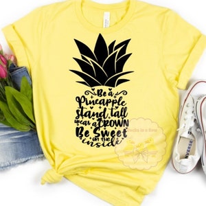 May include: Yellow t-shirt with a black pineapple graphic and the text "Be a Pineapple Stand Tall Wear a Crown Be Sweet on the Inside".
