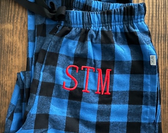 May include: Blue and black plaid pajama pants with a red embroidered monogram "STM".