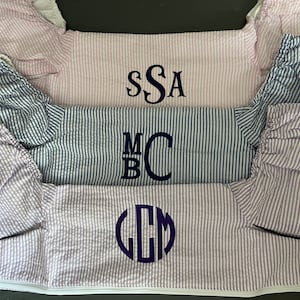 May include: Three striped fabric items with different embroidered monograms. The top item is pink with the monogram "SSA", the middle item is blue with the monogram "MBC", and the bottom item is purple with the monogram "LCM".