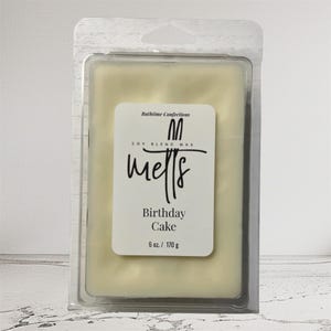 May include: A rectangular wax melt in a clear plastic clamshell. The wax is a pale yellow color. A white label reads "Bathime Confections" and "melts" with "Birthday Cake" below. The label also states the wax is 6 oz / 170 g.