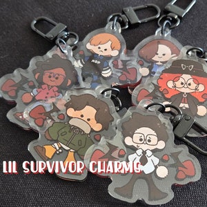 May include: Six colorful cartoon character keychains with black metal rings. Each keychain features a different character with a unique design and personality. The characters are surrounded by red hearts. The text "Lil Survivor Charms" is visible at the bottom of the image.