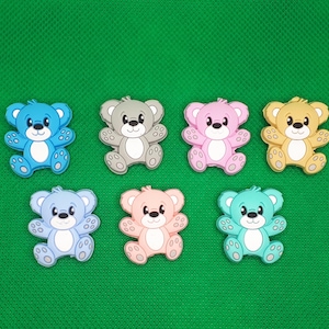 Può includere: Sei piccoli ciondoli in silicone a forma di orsacchiotto in vari colori pastello: azzurro, grigio, rosa, marrone chiaro, azzurro e turchese.