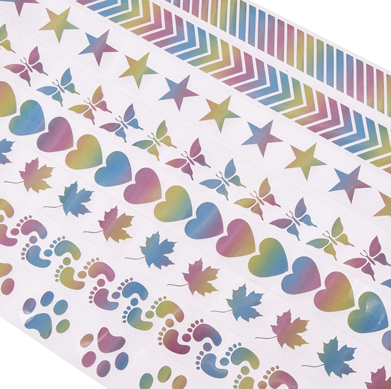 May include: A sheet of colorful holographic stickers with various designs, including stars, butterflies, hearts, maple leaves, footprints, and paw prints.