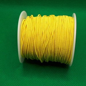 May include: A spool of bright yellow elastic cord.