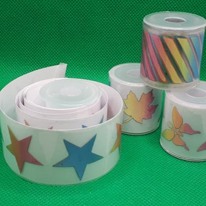May include: Four rolls of colorful patterned washi tape. The tape features designs of stars, leaves, butterflies, and stripes. The tape is rolled up and ready to be used for crafting or decorating.
