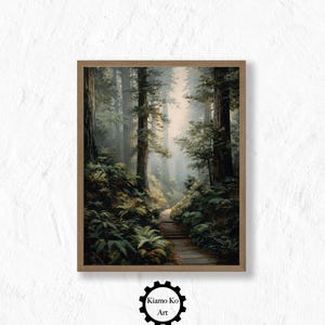 May include: A framed print of a forest scene. The artwork depicts a path winding through tall trees with lush green ferns and foliage. The color palette is dominated by greens, browns, and soft light, creating a serene and natural ambiance. The artwork is signed "Kiamo Ko Art".