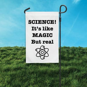 May include: White garden flag with black text that reads "SCIENCE! It's like MAGIC But real" and a black atom symbol.