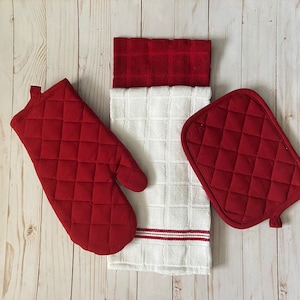 May include: Red quilted oven mitts and pot holders. The oven mitt has a loop for hanging. The pot holders are square shaped.
