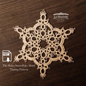 May include: A beige crocheted snowflake motif tatting pattern. The pattern is on a brown wooden surface. The text "The Boho Snowflake Motif Tatting Pattern" is below the snowflake. The text "La Sincérité Hong Kong Est 2018" is above the snowflake.
