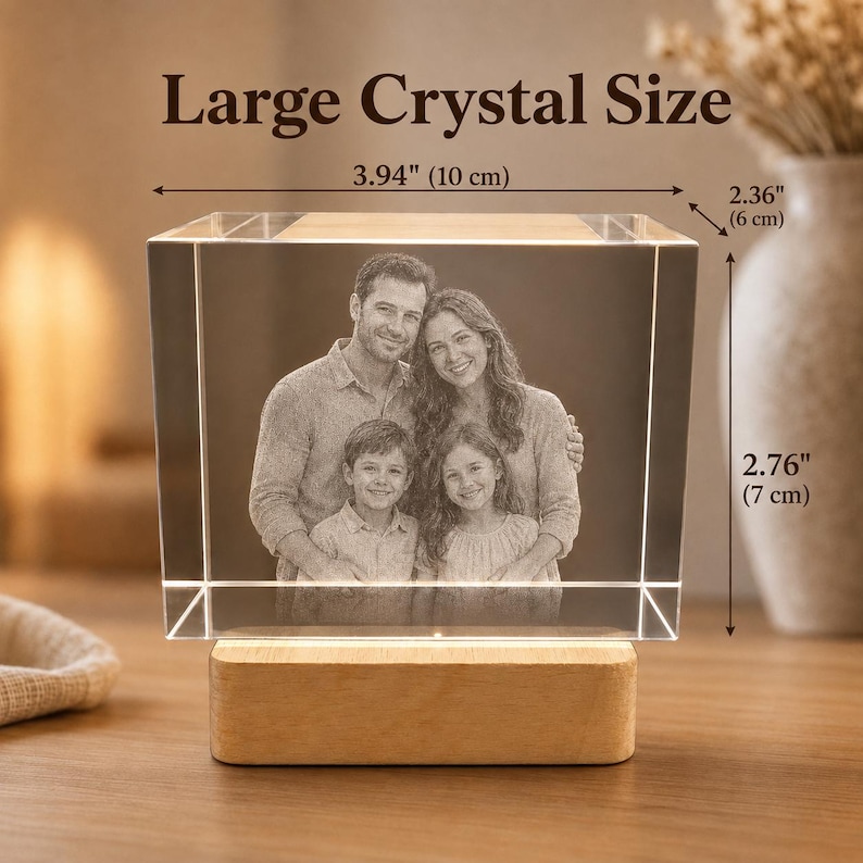 May include: A rectangular crystal block featuring a laser-etched family portrait of two adults and two children. The crystal sits on a light wood base and measures 3.94 inches wide, 2.36 inches deep, and 2.76 inches tall, labeled Large Crystal Size.