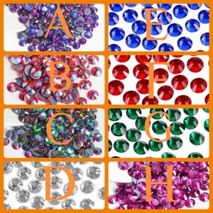 K&ouml;nnte beinhalten: Eine Auswahl an farbigen Strasssteinen in verschiedenen Farbt&ouml;nen, darunter Lila, Rot, Gr&uuml;n, Blau, Silber und Rosa. Jede Farbe wird in einem separaten Abschnitt mit einem Buchstaben angezeigt. Die Strasssteine sind rund und haben eine reflektierende Oberfl&auml;che.