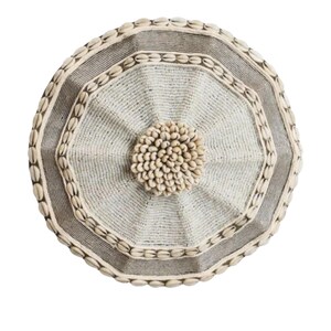 May include: Round, decorative wall art featuring a central cluster of small, light-colored shells. The design incorporates concentric octagonal shapes with a textured, woven appearance. The outer edges are adorned with more shells, creating a natural, earthy aesthetic.