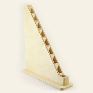 Pu&ograve; includere: Un supporto in legno con forma triangolare e pi&ugrave; fessure per riporre oggetti. Il supporto &egrave; in legno chiaro e ha una finitura naturale.