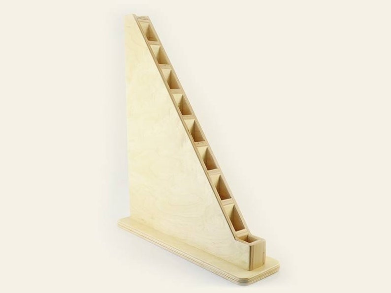 Pu&ograve; includere: Un supporto in legno con forma triangolare e pi&ugrave; fessure per riporre oggetti. Il supporto &egrave; in legno chiaro e ha una finitura naturale.