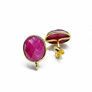 Pode incluir: Um par de brincos de ouro com pedras preciosas rosa de forma oval.