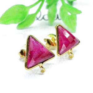 May include: A pair of gold triangle earrings with pink gemstone accents.