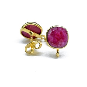 Peut inclure: Une paire de boucles d'oreilles en or avec des accents de pierres précieuses rouges. Les boucles d'oreilles ont une fermeture à tige.