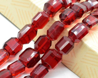 Puede incluir: Una hebra de cuentas de vidrio facetadas de color rojo intenso. Las cuentas son de forma rectangular y tienen un acabado brillante.