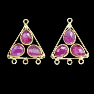 May include: A pair of gold triangle-shaped earring charms with three pink gemstone accents. Each charm has three jump rings for attaching to jewelry.