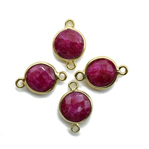 Pode incluir: Quatro pingentes de conector dourados com pedras redondas e facetadas de cor rubi vermelho. Cada pingente tem dois laços para prender em joias.