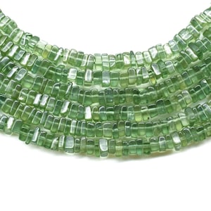 May include: A strand of green gemstone beads, each bead is a rectangular prism with slightly rounded edges.