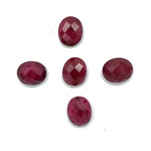 May include: Five oval-shaped, faceted gemstones in a deep red hue are arranged against a white background. The gems have a polished, reflective surface, suggesting they are rubies or similar precious stones, ideal for jewelry making.