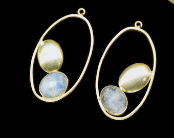 Può includere: Un paio di orecchini ovali in oro con due pietre ovali, una bianca e una blu, incastonate in ogni orecchino.