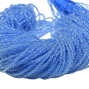 May include: A large spool of light blue seed beads. The beads are small and round, and they are strung together in a long strand.