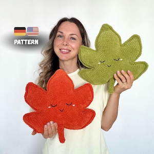 May include: Two leaf-shaped plush pillows, one orange and one green, each with a smiling face. The pillows are held up by a person. The word "PATTERN" is in the image.