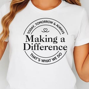 May include: White t-shirt featuring a black circular design with the words "Making a Difference". The text "Today, Tomorrow & Always" and "That's What We Do" are also included in the design. The shirt has short sleeves.