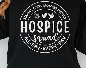 May include: Black sweatshirt with a white circular graphic that reads "Making Every Moment Matter" and "Hospice Squad All Day Every Day." The graphic includes a handshake, a heart, and a dove. The sweatshirt has long sleeves.