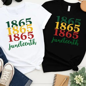 Può includere: Due magliette con la scritta "1865 Juneteenth" stampata su di esse. Le magliette sono nera e bianca e hanno uno schema di colori rosso, giallo e verde.
