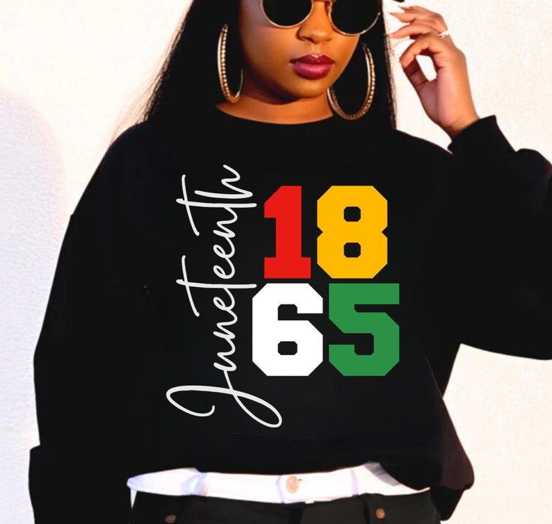 May include: Black sweatshirt with a white graphic that says "Juneteenth 1865" in red, yellow, white, and green.