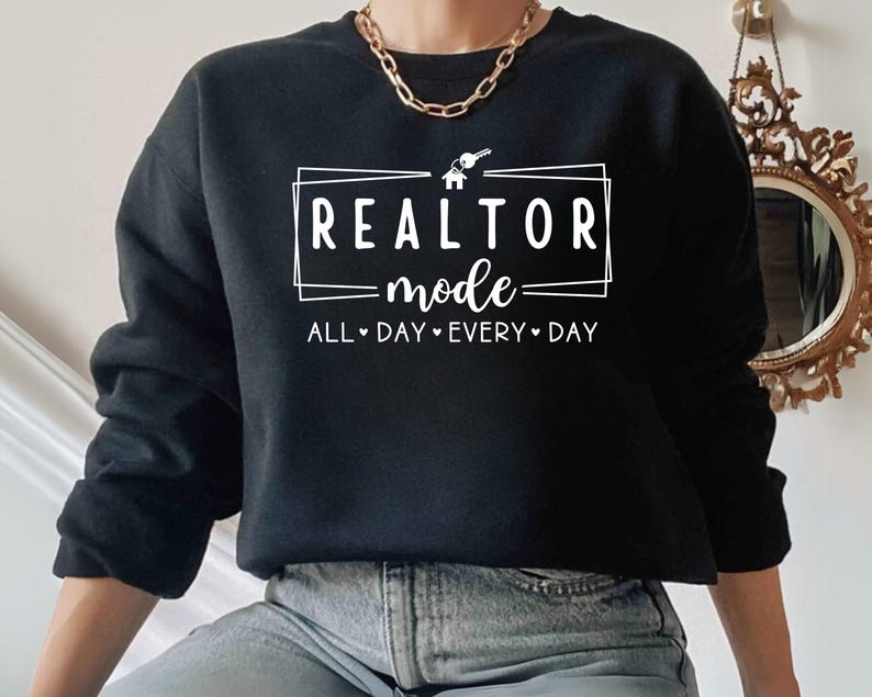 May include: Black sweatshirt with white text that reads "Realtor mode - All day every day" with a house and key graphic.