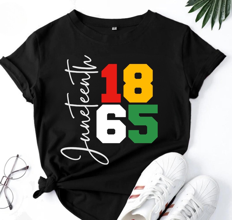 May include: Black t-shirt with white text that says "Juneteenth 1865". The numbers are in red, yellow, white, and green squares.