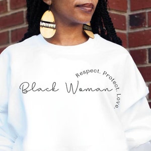 Puede incluir: Sudadera blanca con el texto "Black Woman" y la frase "Respect. Protect. Love." en un círculo alrededor de la palabra "Woman".
