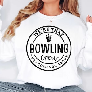 May include: White sweatshirt with a black circle graphic that says "We're That Bowling Crew They Told You About" with a bowling pin and ball graphic inside the circle.