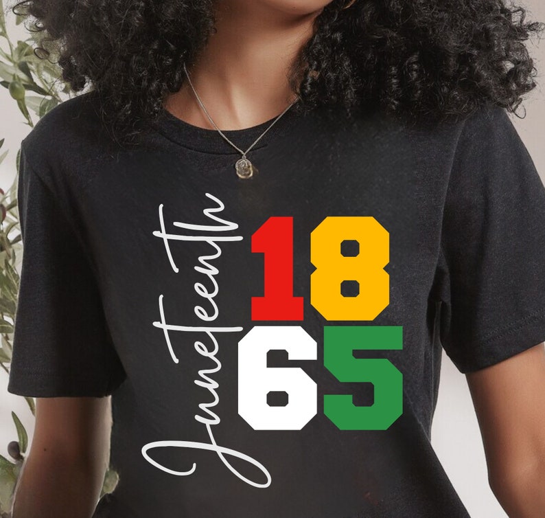 May include: Black t-shirt with the text "Juneteenth 1865" in white, red, yellow, and green.