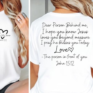 May include: White t-shirt with a black heart and the text "Love like Jesus John 15:12" on the front. The back of the shirt has the text "Dear Person Behind me, I hope you know Jesus loves you beyond measure I pray he blesses you today Love♡ -The person in front of you John 15:12"