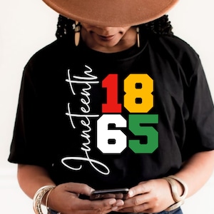 May include: Black t-shirt with the text "Juneteenth 1865" in red, yellow, white, and green.