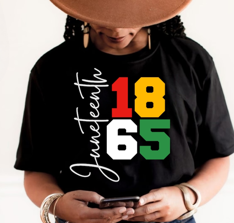May include: Black t-shirt with the text "Juneteenth 1865" in red, yellow, white, and green.