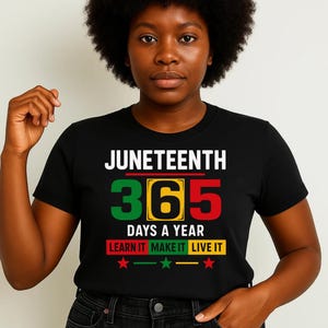 May include: Black t-shirt with the text "Juneteenth 365 Days a Year Learn It Make It Live It" in white and green, red, and yellow. There are three red stars below the text.