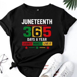 May include: Black t-shirt with the text "Juneteenth 365 Days a Year Learn It Make It Live It" in white and green lettering. The number 365 is in green, yellow, and red.