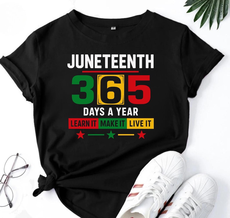May include: Black t-shirt with the text "Juneteenth 365 Days a Year Learn It Make It Live It" in white and green lettering. The number 365 is in green, yellow, and red.